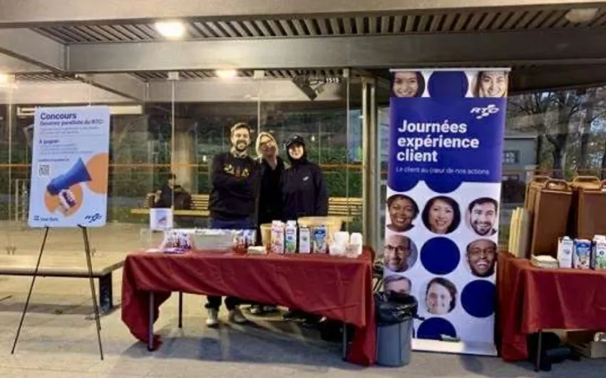 Des employés du RTC sourient à un kiosque.