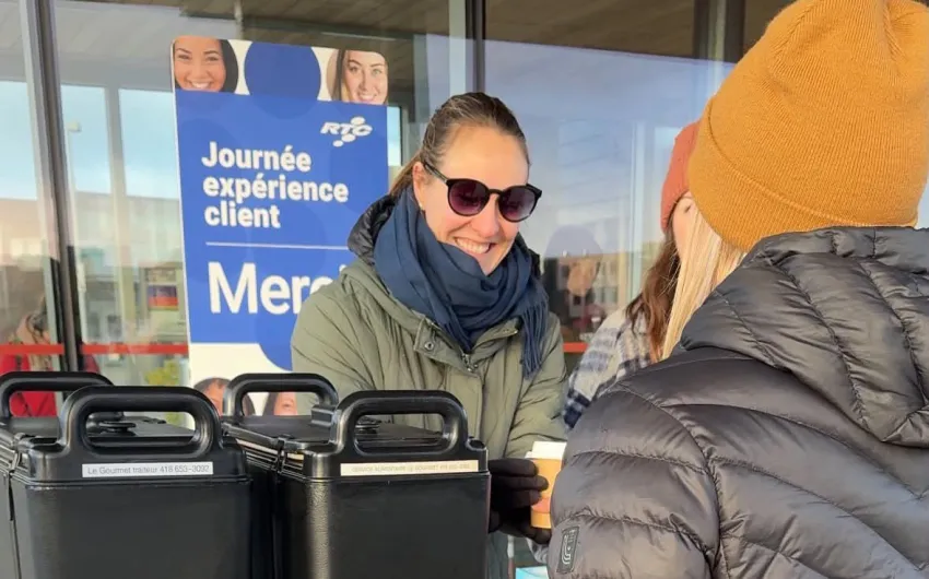 Une employée du RTC tend un café à une cliente.